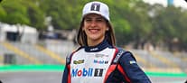 Antonella Bassani, pilota da Porsche Cup, usando boné preto e uniforme de corrida com detalhes da Mobil.
