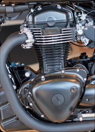 Motor limpo de motocicleta em close-up, com destaque para componentes metálicos e acabamento preto.