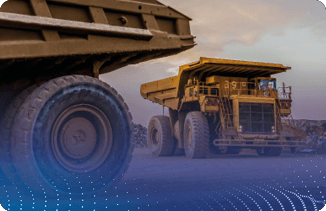 Caminhões de mineração amarelos operando em área de extração com solo rochoso.
