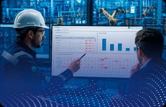 Profissionais analisando indicadores de monitoramento industrial em tela com gráficos e tabelas.