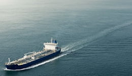 Dois navios nas cores azul e vermelho, em alto mar ilustrando o uso de produtos e serviços marítimos Mobil